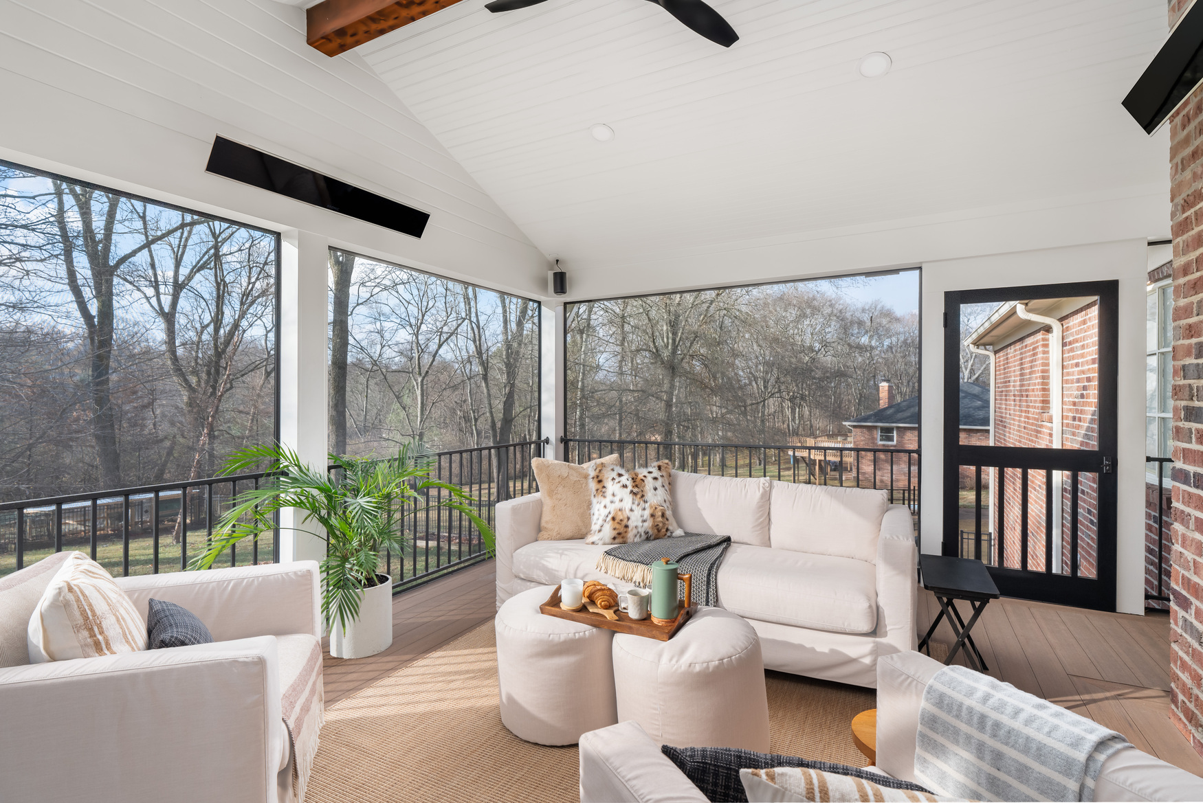 Screened porch with a stone fireplace and exposed timber beams
